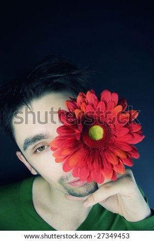 portrait of a young guy with a flower on a black background