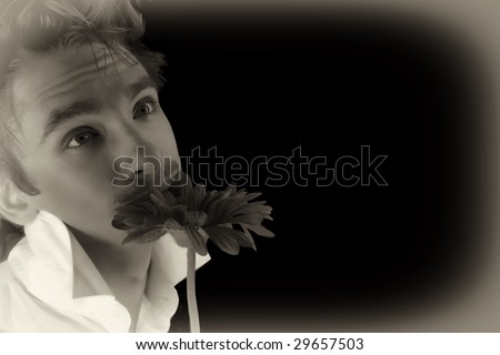 young man with a red flower isolated on a black background