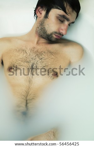 stock photo portrait of a young sexual tanned naked guy in bath