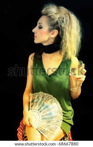 young woman with  fan and  glass of wine on  black background