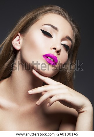Beautiful woman with bright make up eye with sexy black liner makeup and pink lips.  Fashion big arrow shape on woman\'s eyelid. Chic evening make-up