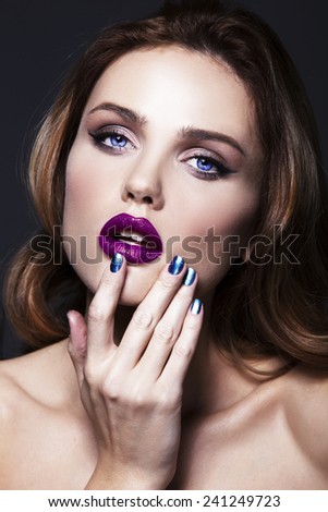 Fashion young model with chic lips make-up with violet lips and bright manicure
