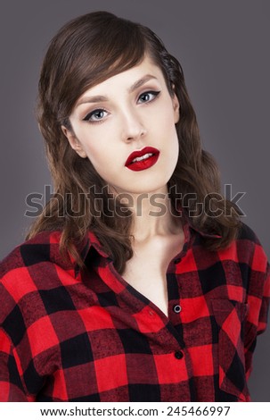 Close up studio fashion portrait of beautiful sensual woman with full berry sexy lips and big blue eyes , wearing red plaid shirt Toned bright colors.