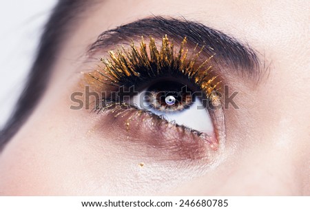 Gold lashes,Macro shot of woman\'s beautiful eye with extremely long eyelashes. Sexy view, sensual look,green eyes