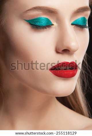 Beautiful woman with bright make up eye with sexy green liner makeup,matt red lips. Fashion big arrow shape on woman\'s eyelid. Chic evening make-up