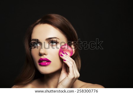 Fashion, health, beauty and spa concept - beautiful woman with rose leaf sponge and pink lips and pink manicure, in black background