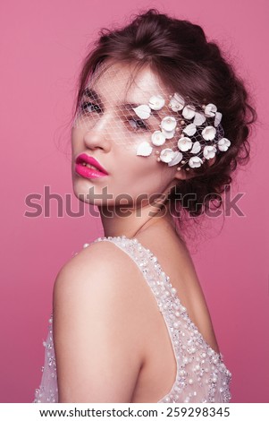 Bride.Young fashion model with perfect skin and make up, pink  background, curly hair, flowers in hair
