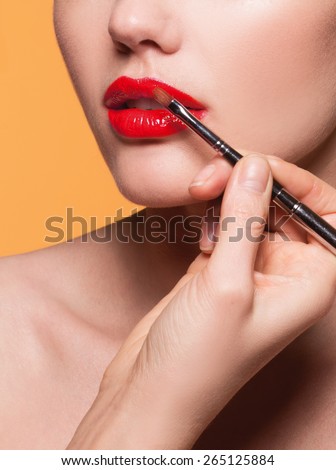 Professional Lips Make-up. Lipgloss and Brush. Lipstick. Beauty Girl Applying Lip Gloss