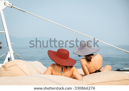 women lounging on a catamaran