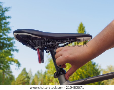 Adjusting a bicycle seat height using a small hex key.