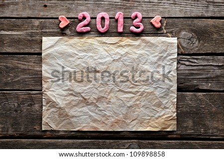 Old crumpled paper and numbers 2013 on old wood. Sweet New Year holiday background.