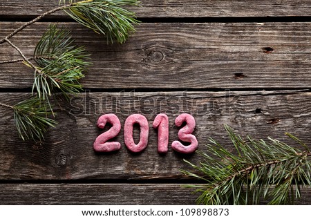 Numbers 2013 with spruce twigs on old wood. Sweet New Year holiday background.