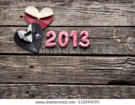 Symbolic male and female heart shapes with 2013 numbers. On old vintage wooden background.