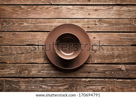 Empty ceramic dishes on old wooden table.