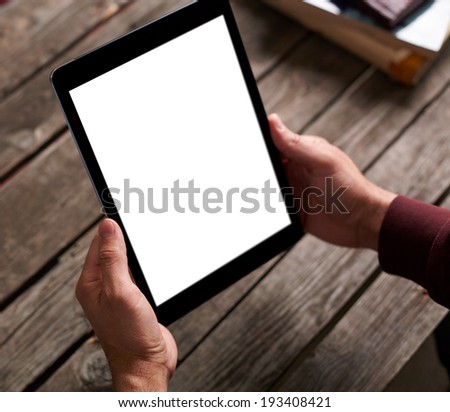 Digital tablet computer with isolated screen in male hands over cafe background Digital tablet computer with isolated screen in male hands over cafe background