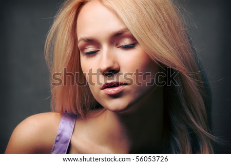 Close-up portrait shot of a beautiful young sexy woman with closed eyes and open mouth. On dark grunge background.