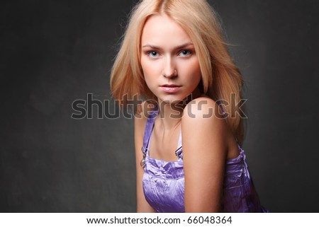 Close-up portrait shot of a beautiful young sexy woman with slightly open mouth. On dark grunge background.