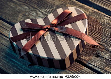 Heart shaped Valentines Day gift box on old wood. Holiday thematics.