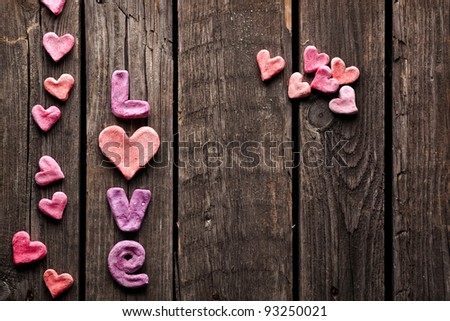 Word Love with heart shapes on old vintage wood plates. Sweet holiday background.
