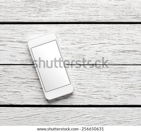 White smart phone on white wooden desk. Clipping path included.