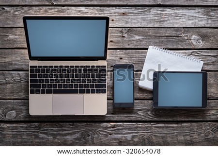 Responsive mock-up of laptop, digital tablet and smartphone, top view on a desktop. Clipping paths for all screens are included.