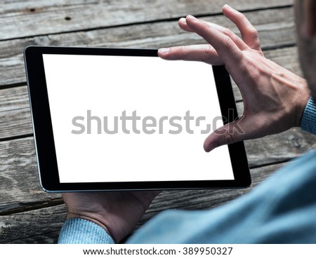 Tablet computer in male hands over table. Clipping path included.