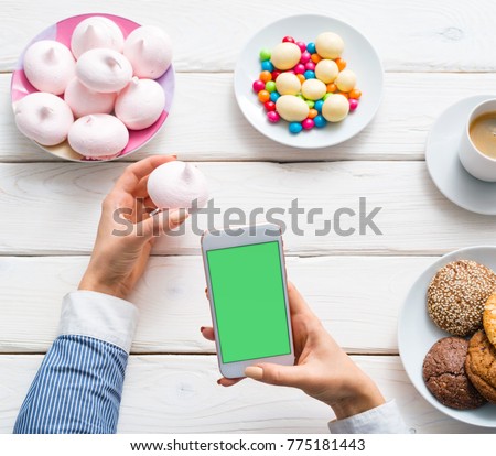 Girl blogger taking a food photo with smartphone camera. Clipping path.