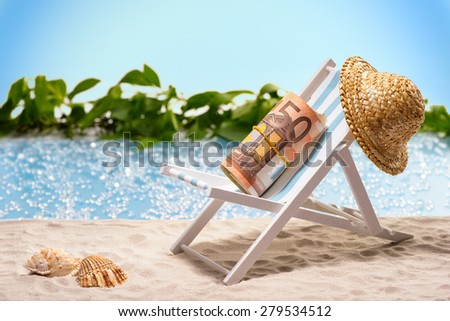 Money on vacation, pack of 50 Euro bills sitting at the beach on a sun lounger in front of a blue lagoon