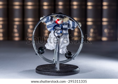 Self moving clown figure doing cartwheels on a desktop in front of a row of brown old books