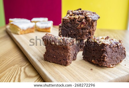 mouthwatering chocolate nut cake and icing cake on wooden board