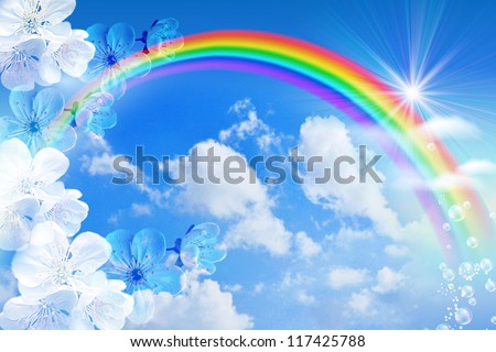 White flowers and rainbow against the sky