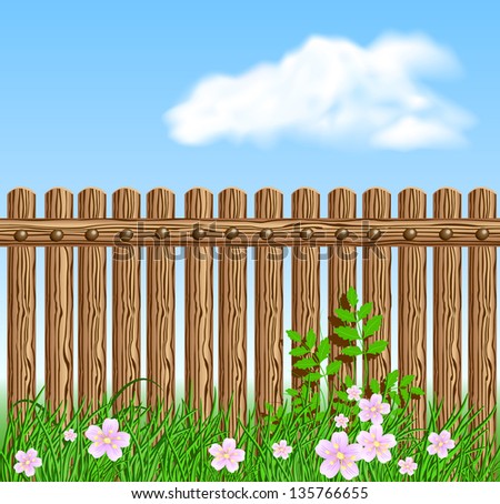 Wooden fence on green grass with flowers against the sky