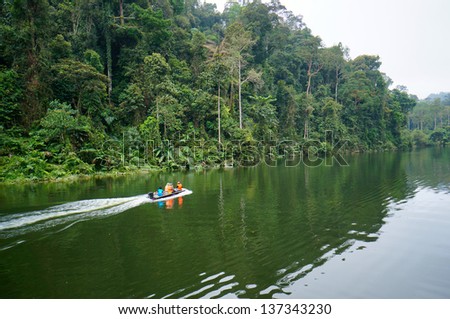 Fishing boat at tropical rainforest at Kenyir Lake in Terengganu, Malaysia, a man made lake built for purpose of hydroelectric power supply