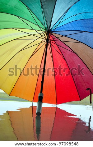 Opened multi-colored umbrella with reflection.