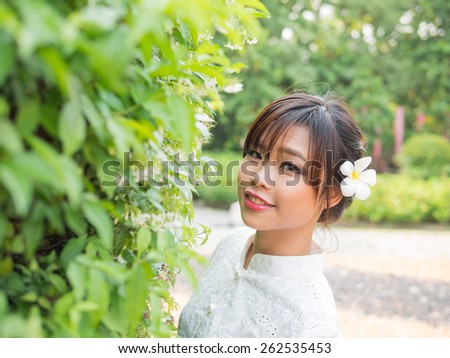 Asian girl in Lanna suit (The traditional cloths in Northern province of Thailand) stand alone with West Indian Jasmine