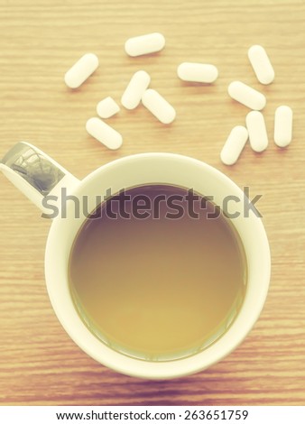 Cup of coffee with medicine pills, Vintage style filter