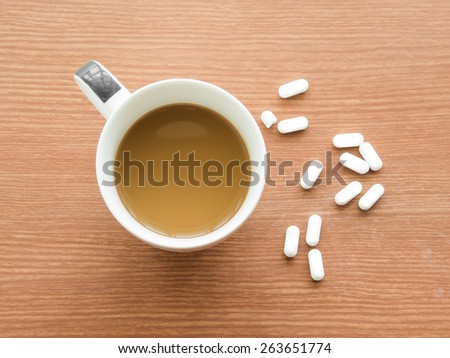 Cup of coffee with medicine pills