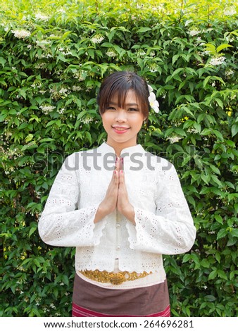 Asian girl in Lanna suit (The traditional cloths in Northern province of Thailand) stand alone and pay respect