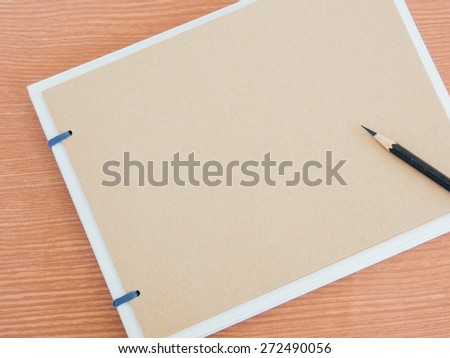 Scrapbook or Sketch book with black pencil on wood background