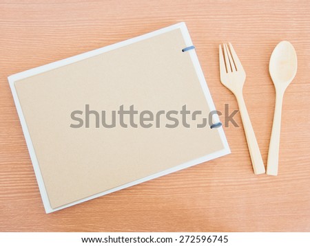 Brown scrapbook or sketch with fork and spoon on wooden table, Concept for menu or healthy food