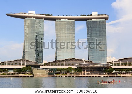 Singapore, Singapore - May 18, 2015: The hotel Marina Bay Sands at the Marina Bay and a rowing boat. Its a luxury resort famous for its infinity swimming pool. The hotel is a landmark  in Singapore.