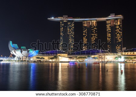 Singapore, Singapore - May 18, 2015: Marina Bay Sands hotel at night with light and laser show in Singapore. The luxury resort is a landmark in Singapore. The laser show starts every evening.