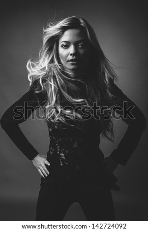 Black and white studio dark portrait of beautiful blonde caucasian girl