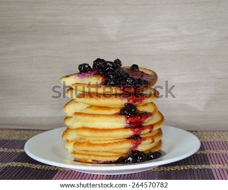 Fluffy pancakes with syrup on wooden table