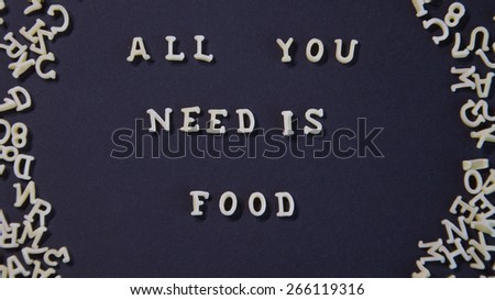 Words All You Need Is Food Written With Pasta Letters, on a black background
