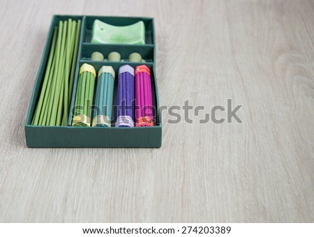 Set of incense sticks in a green box on grey background