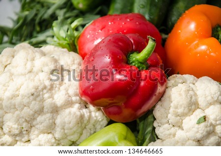 Colorful peppers with cauliflowers, cucumbers and tarragon. Fresh vegetables at summer day