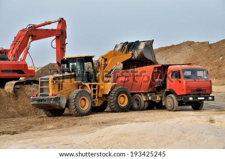 Excavator loading tipper truck on a construction site