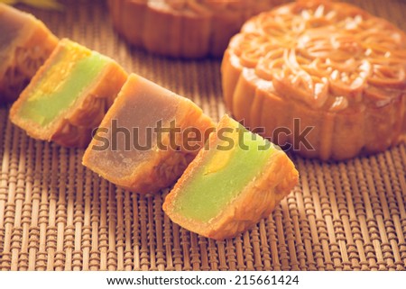Chinese mid autumn festival foods. Traditional mooncakes on bamboo background. Retro vintage style.