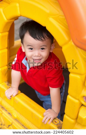 Happy laughing cute little three years old asian child boy or kid playing in a yellow house on a playground. Healthy lifestyles concept. Happiness without limit, happy asian child outdoor, face focus.